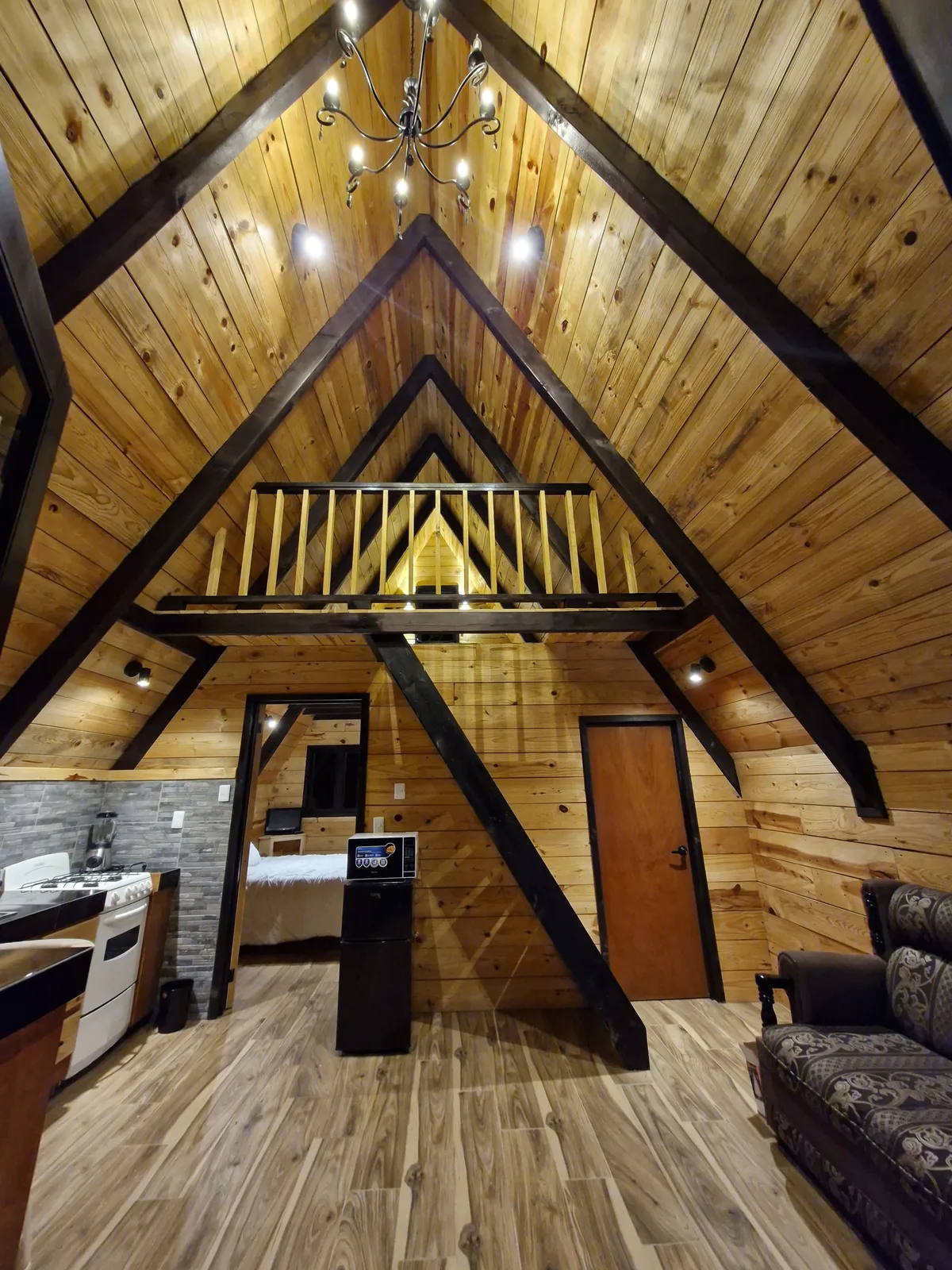 Interior a doble altura con vigas de madera y candil