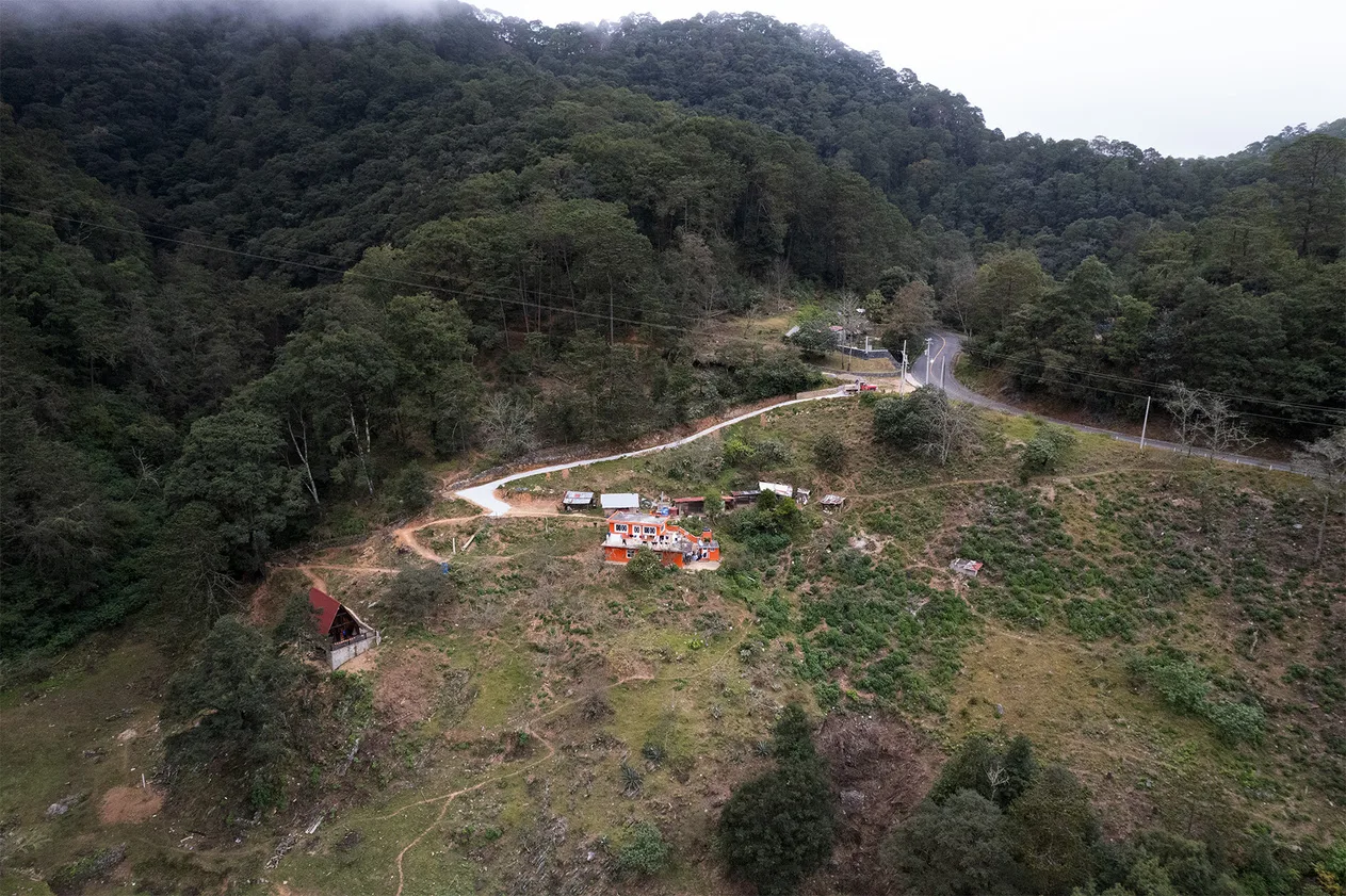Vista aérea del entorno de la cabaña, con el camino que sube desde la carretera